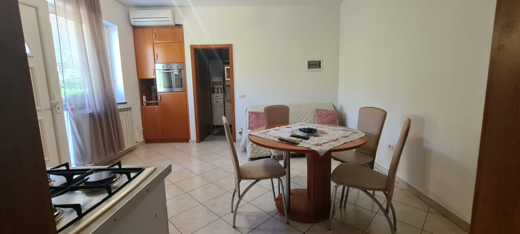 Dnevna soba z jedilnim kotom in klimo v apartmaju Strunjan