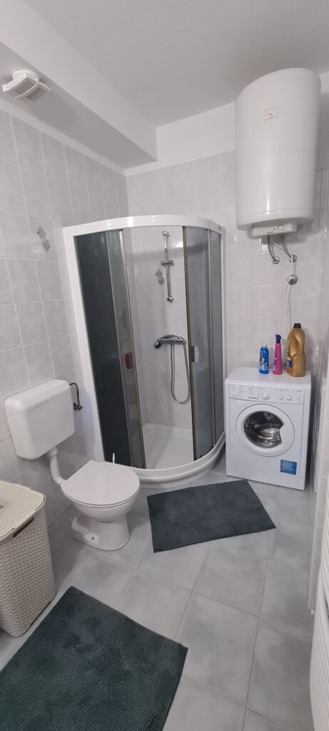 Kopalnica s prho, straniščem in pralnim strojem v apartmaju Strunjan